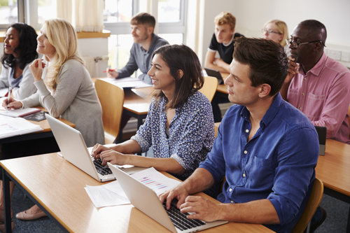 Les élèves apprennent à des bureaux équipés d'ordinateurs portables